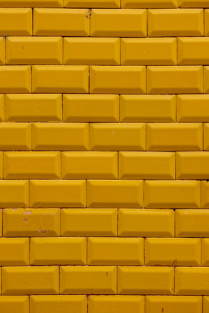 Closeup view of a Yellow ceramic brick wall texture background.