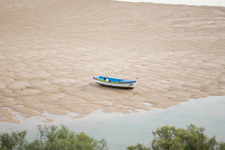 Fishing boat on a landscape view to the beach and ocean from Cacela Velha village, located in the Algarve region, Portugal.の写真素材