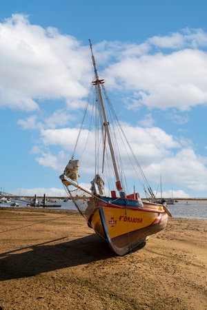 ALVOR, PORTUGAL - 16th APRIL, 2023: Beautiful Portuguese traditional fishing boat painted yellow, blue and red.のeditorial素材