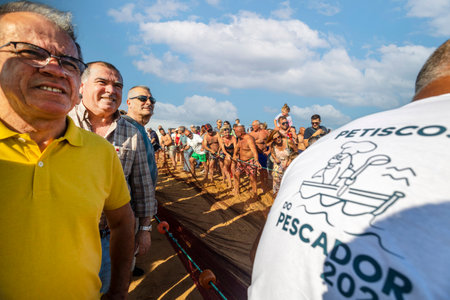 QUARTEIRA, PORTUGAL - 6th JUNE 2023: Cast net fishing tradition done by the local population at beach seashore.のeditorial素材