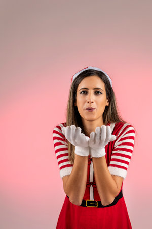 Red female santa blowing action with white gloves and red background.の写真素材