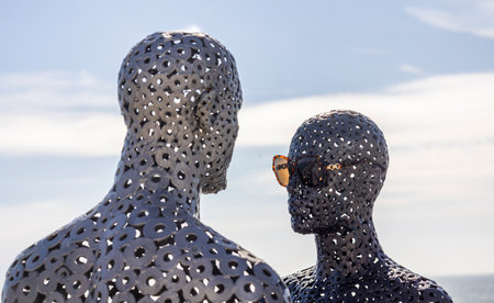 Metal tubes sculpture of a man and a woman wearing sunglasses in Albufeira city.の写真素材