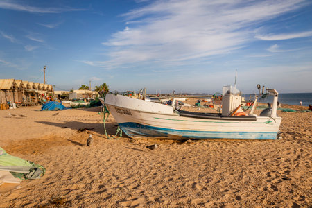 Traditional Portuguese fishing boat anchored on the beach in the Algarve region.の写真素材