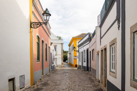 Cobblestone street and historical house in Faro city, Algarve, Portugal.