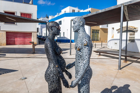 Metal tubes sculpture of a man and a woman wearing sunglasses in Albufeira city.のeditorial素材