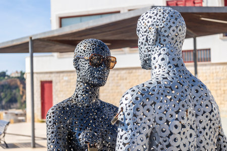 Metal tubes sculpture of a man and a woman wearing sunglasses in Albufeira city.の写真素材