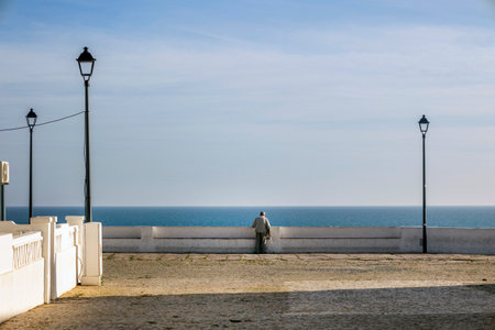 Close view of a lonely old man walking to watch the ocean.の写真素材
