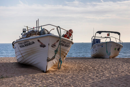 Traditional Portuguese fishing boat anchored on the beach in the Algarve region.の写真素材