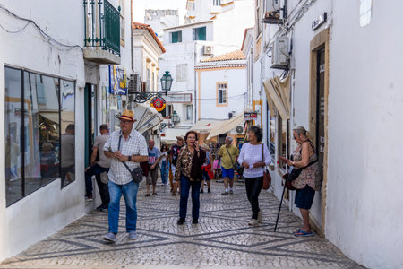 ALBUFEIRA, PORTUGAL - 7th MAY 2024: Albufeira city downtown businesses with people walking around.のeditorial素材