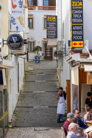 ALBUFEIRA, PORTUGAL - 7th MAY 2024: Albufeira city downtown businesses with tourists having a good time in the bars and restaurants.のeditorial素材