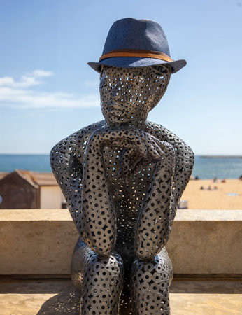 Metal statue of woman sitting in a beach of Albufeira city, Portugal.の写真素材