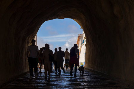 ALBUFEIRA, PORTUGAL - 7th MAY 2024: Access tunnel to the beach creating silhouettes of people.のeditorial素材