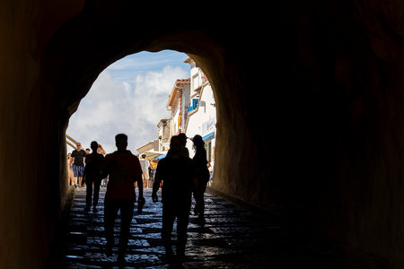 ALBUFEIRA, PORTUGAL - 7th MAY 2024: Access tunnel to the beach creating silhouettes of people.のeditorial素材