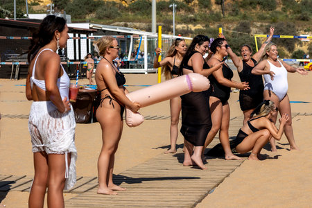 ALBUFEIRA, PORTUGAL - 7th MAY 2024: Group of women doing a bachelorette party in a beach in Albufeira, Portugal.のeditorial素材