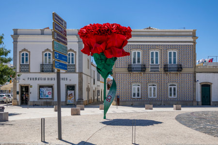 SAO BRAS DE ALPORTEL, PORTUGAL: 4th MAY, 2024 - View of the renovated Sao Bras de Alportel main plaza with large red carnation flower , located in Portugal.のeditorial素材