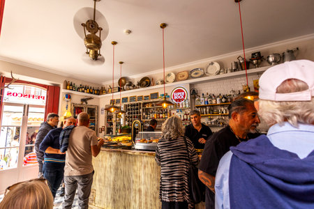 LOULE, PORTUGAL - 17th MARCH 2024: Tourists having a beer near the famous tavern "O Postigo" in a Algarve city.のeditorial素材