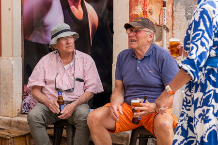 LOULE, PORTUGAL - 17th MARCH 2024: Tourists having a beer on a tavern in a Algarve city.のeditorial素材