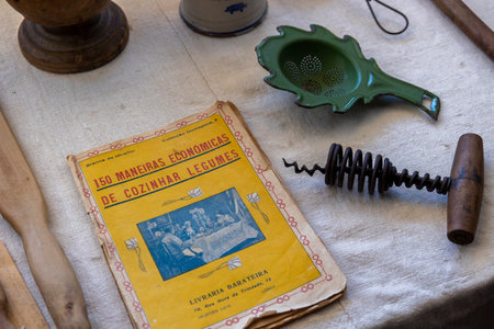 SAO BRAS DE ALPORTEL, PORTUGAL - 6th MAY 2024: Old vintage cookbook with recipes and several other objects on the table.のeditorial素材