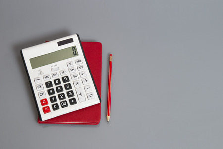 calculator and red pencil on deskの写真素材