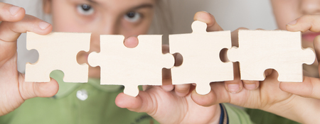 Students combine pieces of puzzleの写真素材