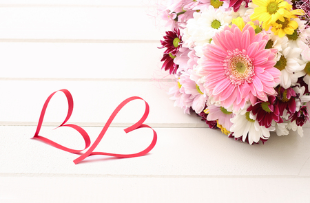 flower bouquet and two heart shape on the tableの写真素材