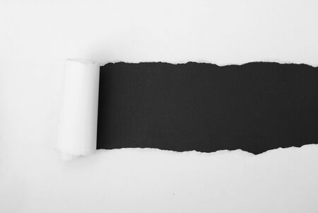 torn white paper frame on black backdropの写真素材
