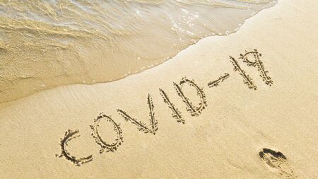 writes covid-19 on the beach. coronavirus measures during the summer holidaysの写真素材