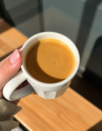 Woman holding a cup of coffee in her hand, close-up