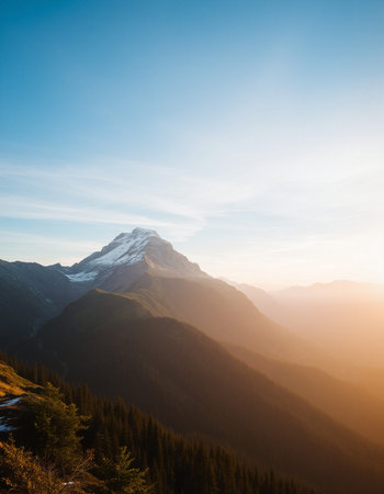 Mountain landscape with snow-capped peaks in the rays of the rising sun