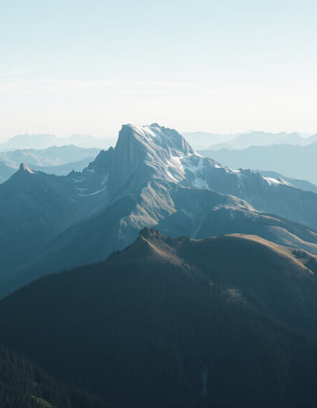 Mountain landscape with snow-capped peaks in the clouds.の写真素材