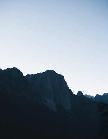 Silhouette of a mountain range in the morning light with blue skyの写真素材