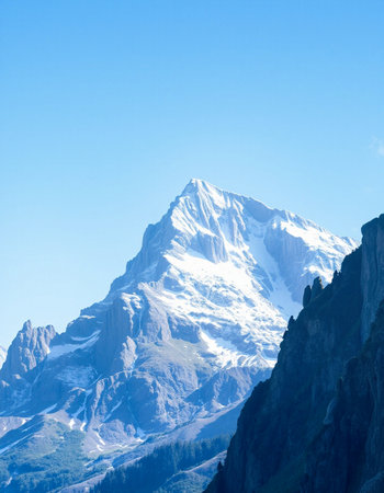 Mountain landscape with snow-capped peaks and blue sky.の写真素材