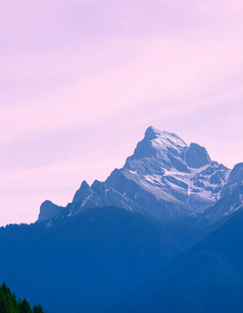 Mountain landscape with snow-capped peaks in the clouds.の写真素材