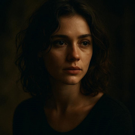 Portrait of a beautiful young woman with curly hair on dark background