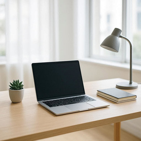 Laptop with blank screen on a wooden table in a modern office