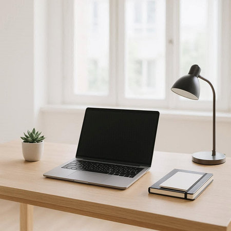 Laptop with black screen on wooden table in office. Workplace concept