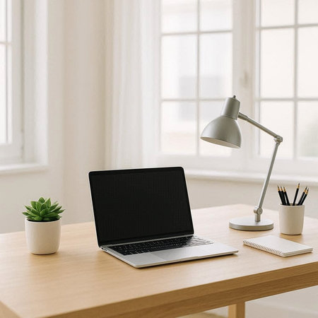 Modern workplace with laptop, stationery and coffee cup on wooden table