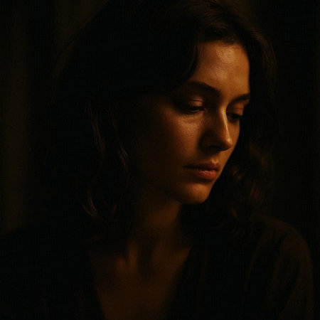 Portrait of a beautiful young woman in a dark room with a black background.