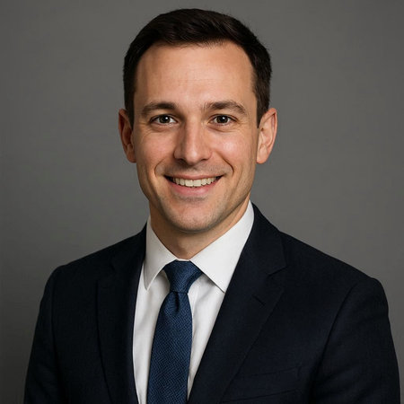 Portrait of a handsome young businessman in a suit on a gray background