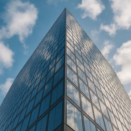 Low angle view of modern skyscraper against blue sky with clouds.の写真素材