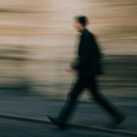 Blurred image of a man walking in the street. Motion blur.の写真素材