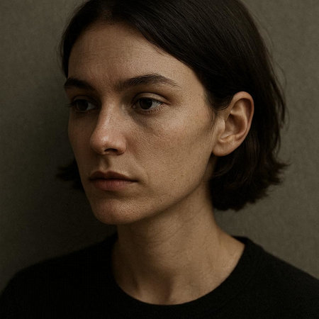 Portrait of a young woman with dark hair and freckles