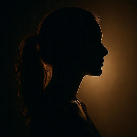 Silhouette of a young girl with long hair in the dark