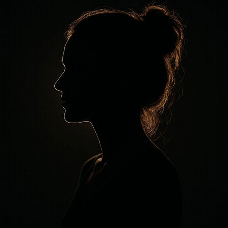 Silhouette of a beautiful young woman in profile on dark background