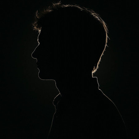 Silhouette of a boy in profile on a black background.