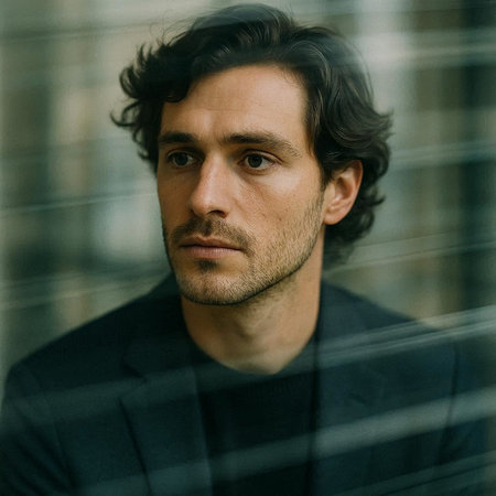 Portrait of a handsome man with dark hair in a black suit