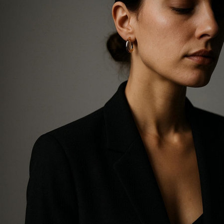 Fashionable woman in black jacket and earrings. Studio shot.