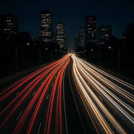 Car light trails on the highway at night with cityscape background.