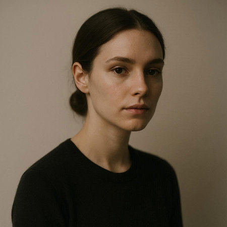 Portrait of a beautiful young woman in a black sweater on a gray background