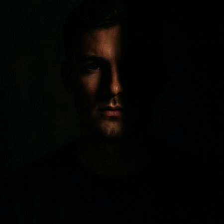 Portrait of a young man in a dark room. Studio shot.